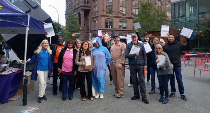 A group of volunteers post in Halloween costumes
