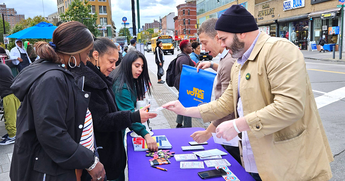 NYC Votes staff members share voting info with Bronx residents at a voter registration table 