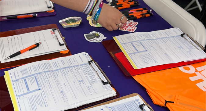 A table with registration forms and a hand over one form